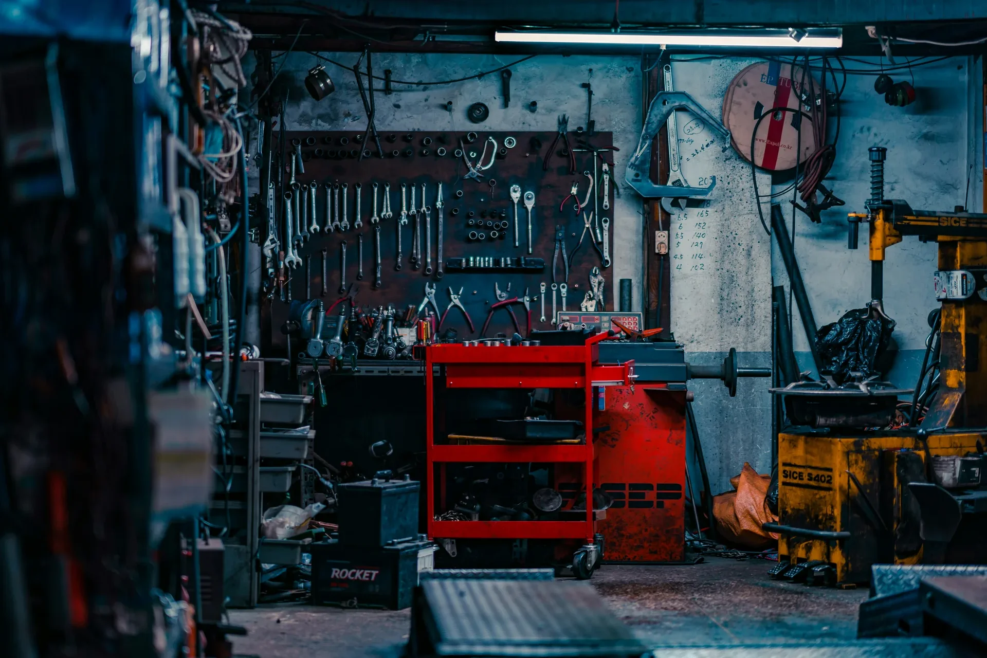 Panneau mural d'outils, servante et équilibreuse de roues dans l'atelier multimarque